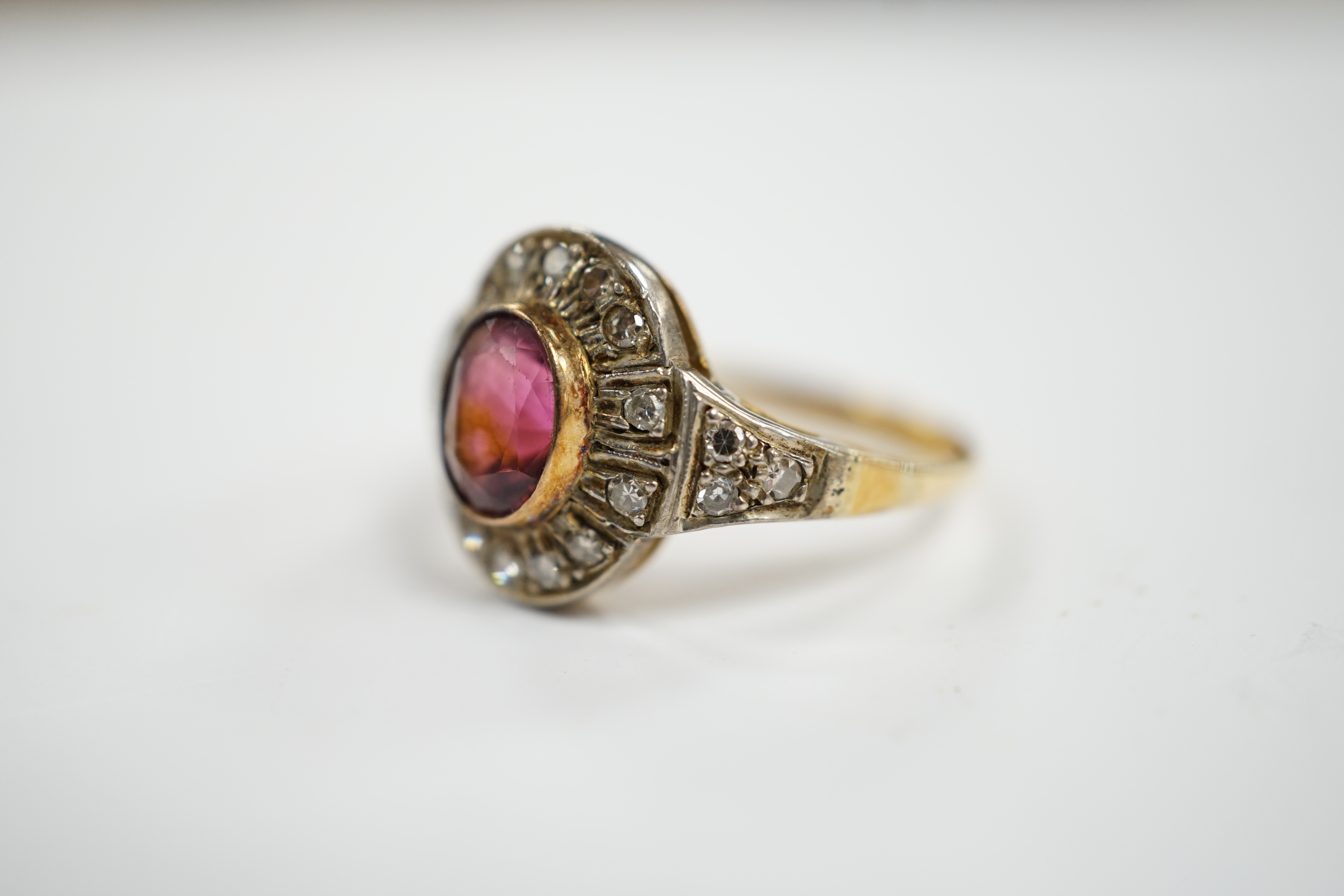 An 18ct, deep pink tourmaline and diamond set oval cluster ring, size P/Q, 4.4 grams